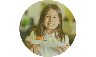 Niña llevando bandeja en comedor escolar
