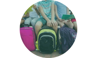 Niños sentados con mochilas